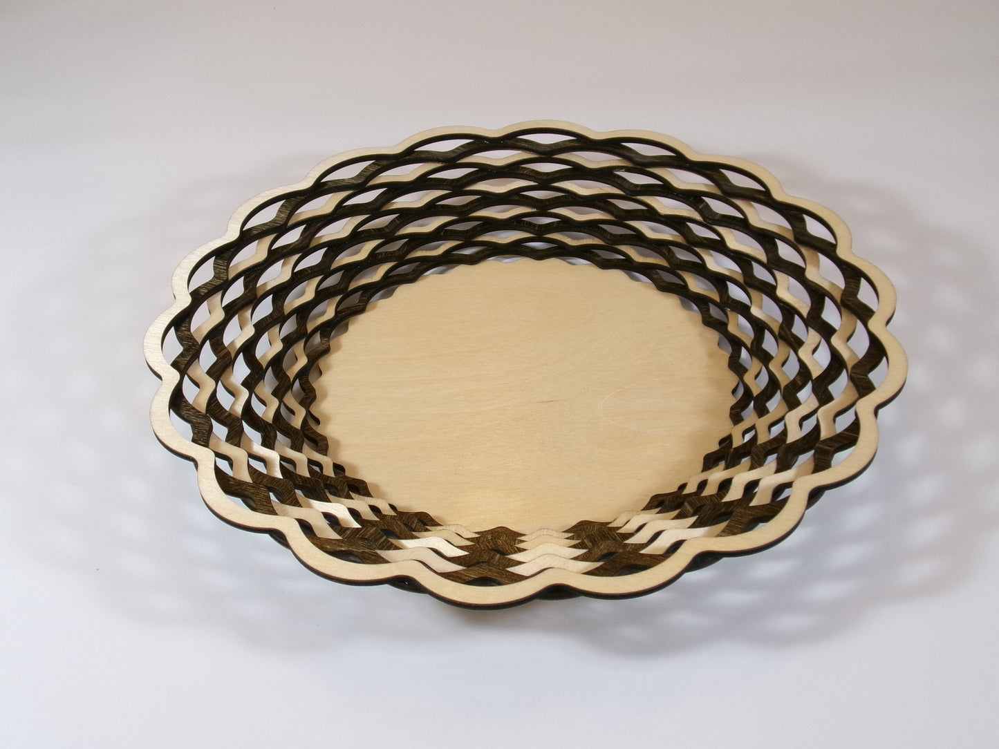 This uniquely designed basket is made with alternating light and dark stained rings that create a beautiful patterned accent decor. This laser cut piece is 10 5/8" diameter and 1 3/8" high. What a wonderful and special gift for someone who appreciates the craftsmanship and time to create this beautiful wall art. 