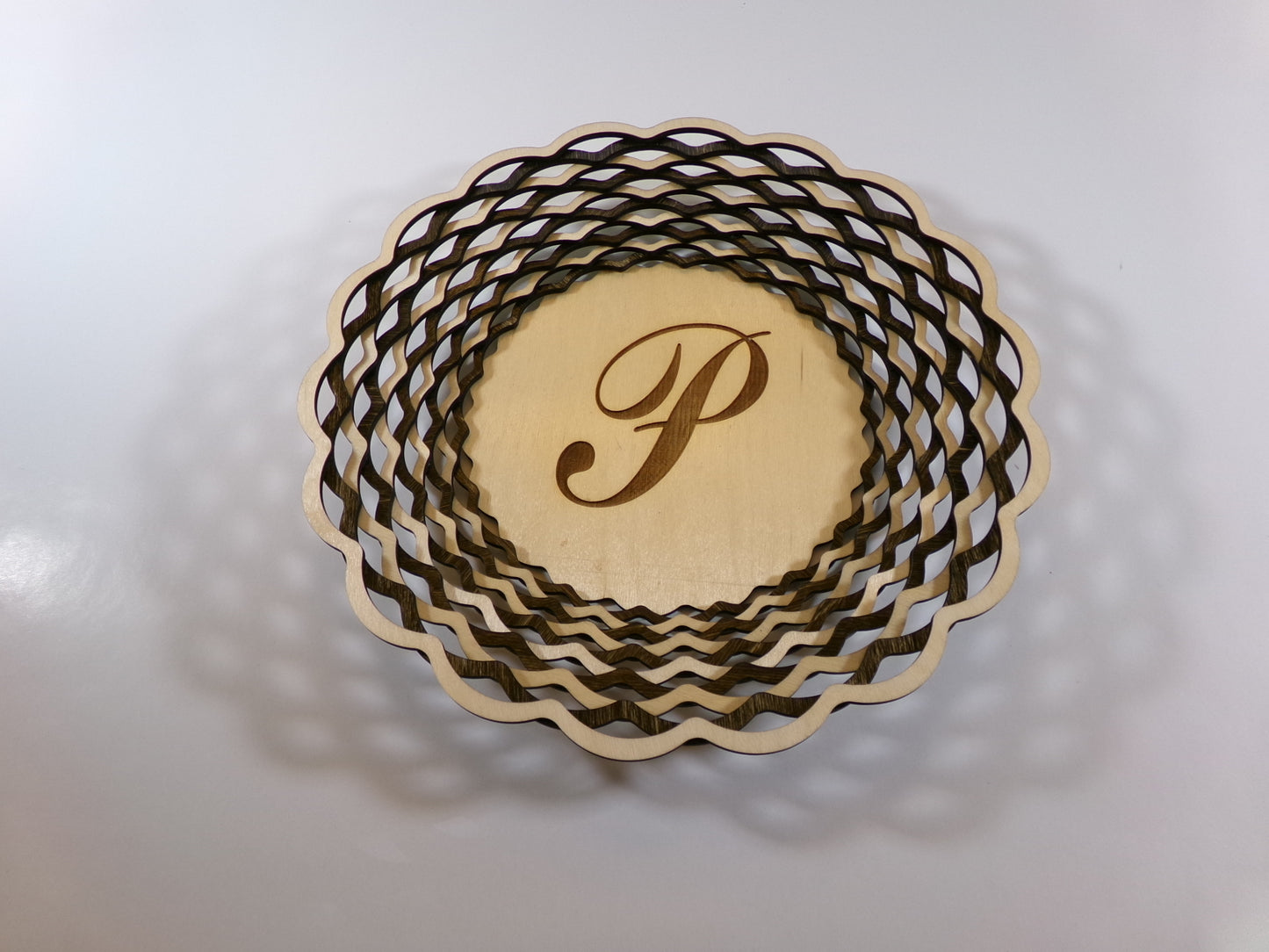 Nothing speaks stronger to someone better than a gift that is personalized. This uniquely designed basket is made with alternating light and dark stained rings that create a beautiful, patterned accent decor. This piece is 10 5/8" diameter and 1 3/8" high. 