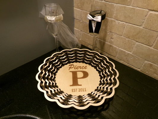 A perfect gift for an anniversary! This uniquely designed basket is made with alternating light and dark stained rings that create a beautiful, patterned accent decor. This piece is 10 5/8" diameter and 1 3/8" high