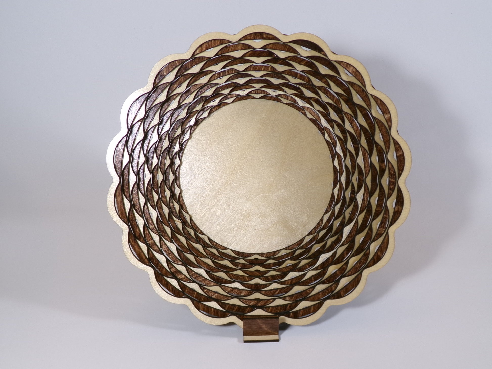 This uniquely designed basket is made with alternating light and dark stained rings that create a beautiful, patterned accent decor. This laser cut piece is 10 5/8" diameter and 2 5/8" high