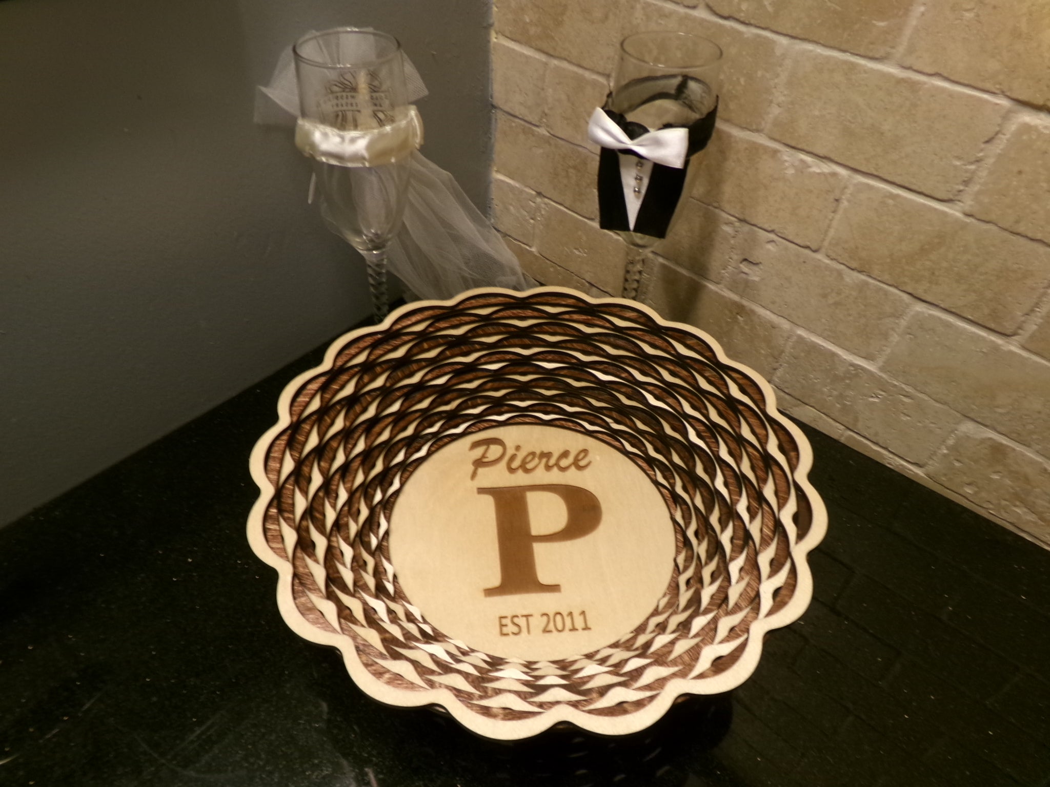 A perfect gift for an anniversary! This uniquely designed basket is made with alternating light and dark stained rings that create a beautiful, patterned accent decor. This piece is 10 5/8" diameter and 2 5/8" high. 